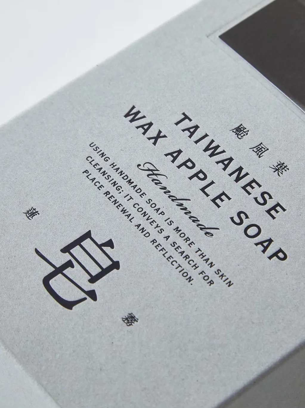 颱風葉蓮霧皂的灰色紙盒特寫,印著 TAIWANESE WAX APPLE SOAP 與「皂」字