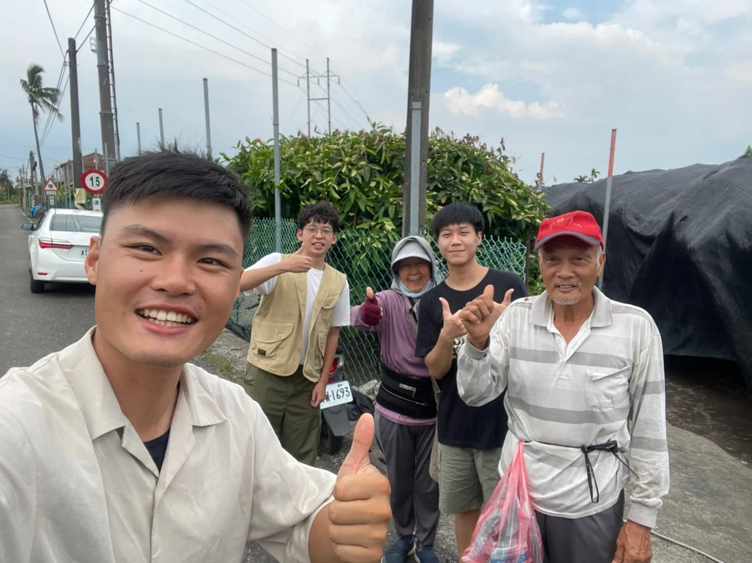 果源創生團隊與年長果農在果園旁的路邊合照